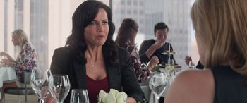 Movie still from “San Andreas” (2015), directed by Brad Peyton – A woman sitting at a table with a bouquet of roses; Close Up shot, Over the shoulder angle