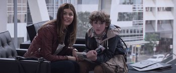 Movie still from “San Andreas” (2015), directed by Brad Peyton – A woman sitting next to a boy on a bus; Medium shot, Over the shoulder angle