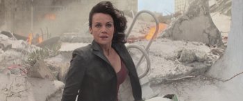 Movie still from “San Andreas” (2015), directed by Brad Peyton – A woman standing in front of a building with rubble; Medium shot, Over the shoulder angle