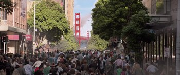 Movie still from “San Andreas” (2015), directed by Brad Peyton – A crowd of people walking down a street near a bridge; Extreme Wide shot, High angle
