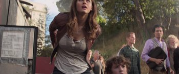 Movie still from “San Andreas” (2015), directed by Brad Peyton – A woman in a brown leather jacket looking up at the sky; Medium shot, Low angle