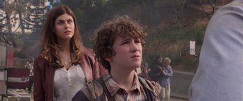 Movie still from “San Andreas” (2015), directed by Brad Peyton – A young man with curly brown hair and a plaid shirt; Close Up shot, Low angle
