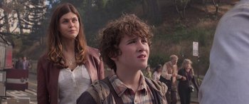 Movie still from “San Andreas” (2015), directed by Brad Peyton – A young man with a curly hair and a plaid shirt; Close Up shot, Low angle