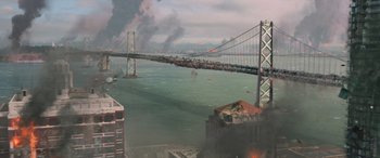 Movie still from “San Andreas” (2015), directed by Brad Peyton – An artistic rendering of a city with a bridge in the middle of it; Extreme Wide shot, High angle
