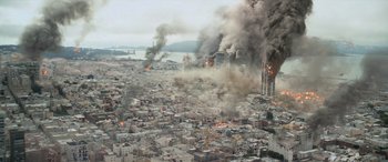 Movie still from “San Andreas” (2015), directed by Brad Peyton – A large fire burning in a city next to a body of water; Extreme Wide shot, High angle
