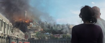Movie still from “San Andreas” (2015), directed by Brad Peyton – Smoke billows from a fire on a hillside; Extreme Wide shot, Over the shoulder angle
