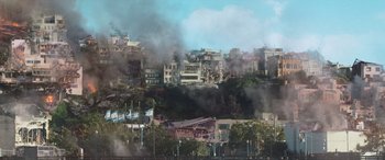 Movie still from “San Andreas” (2015), directed by Brad Peyton – Smoke billows from a building on a city street; Extreme Wide shot, High angle