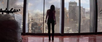 Movie still from “San Andreas” (2015), directed by Brad Peyton – A woman standing in front of a window looking at a city; Wide shot, Low angle