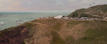 Movie still from “San Andreas” (2015), directed by Brad Peyton – An aerial view of a beach with a tent on top of a hill; Extreme Wide shot, High angle