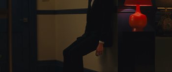 Movie still from “Sanctuary” (2022), directed by Zachary Wigon – A man in a suit leaning against a wall; Medium shot, Low angle