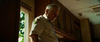 Movie still from “Savage Salvation” (2022), directed by Randall Emmett – An older man wearing a uniform is looking down; Close Up shot, Low angle