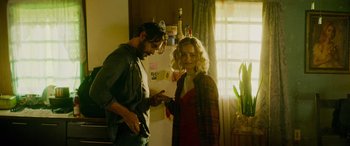 Movie still from “Savage Salvation” (2022), directed by Randall Emmett – A man and a woman standing in a kitchen; Medium shot, Over the shoulder angle