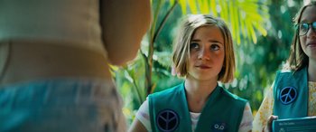 Movie still from “Savage Salvation” (2022), directed by Randall Emmett – A girl in a girl scout uniform looking at a person in the background; Close Up shot, Over the shoulder angle