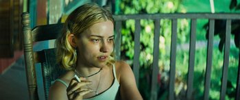 Movie still from “Savage Salvation” (2022), directed by Randall Emmett – A woman sitting outside with a cigarette in her mouth; Close Up shot, Over the shoulder angle