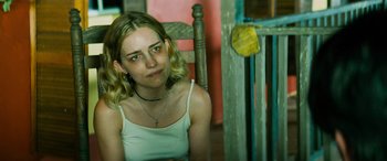 Movie still from “Savage Salvation” (2022), directed by Randall Emmett – A woman sitting in a chair looking at the camera; Close Up shot, Over the shoulder angle