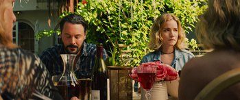 Movie still from “Savage Salvation” (2022), directed by Randall Emmett – A man and a woman sitting at a table with wine glasses; Medium shot, Over the shoulder angle