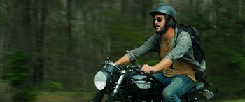 Movie still from “Savage Salvation” (2022), directed by Randall Emmett – A man riding a motorcycle wearing a helmet; Medium shot, Low angle