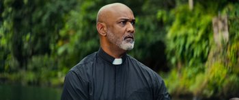 Movie still from “Savage Salvation” (2022), directed by Randall Emmett – A man in a black shirt and a white collar; Close Up shot, Low angle