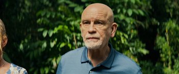 Movie still from “Savage Salvation” (2022), directed by Randall Emmett – An older man with a beard and a blue shirt; Close Up shot, Over the shoulder angle