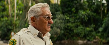 Movie still from “Savage Salvation” (2022), directed by Randall Emmett – An older man wearing glasses looking off into the distance; Close Up shot, Over the shoulder angle