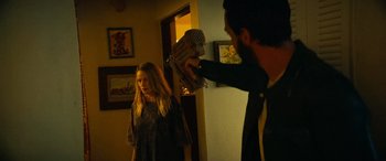 Movie still from “Savage Salvation” (2022), directed by Randall Emmett – A man is holding a microphone up to a woman's face; Medium shot, Over the shoulder angle