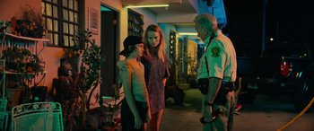 Movie still from “Savage Salvation” (2022), directed by Randall Emmett – Two women and a police officer standing in a hallway; Medium shot, Over the shoulder angle
