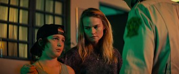 Movie still from “Savage Salvation” (2022), directed by Randall Emmett – Two young people standing next to each other in a room; Close Up shot, Over the shoulder angle