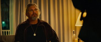 Movie still from “Savage Salvation” (2022), directed by Randall Emmett – A man with long hair and a beard wearing a brown jacket; Close Up shot, Low angle