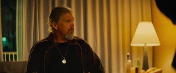 Movie still from “Savage Salvation” (2022), directed by Randall Emmett – A man with a beard and a necklace; Close Up shot, Over the shoulder angle