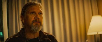 Movie still from “Savage Salvation” (2022), directed by Randall Emmett – A man with a gray beard is looking up; Close Up shot, Low angle