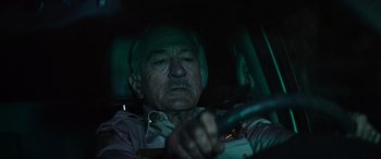 Movie still from “Savage Salvation” (2022), directed by Randall Emmett – An older man driving a car at night; Close Up shot, Over the shoulder angle