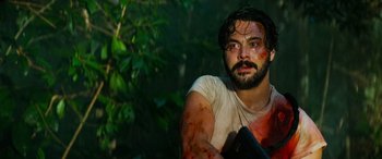 Movie still from “Savage Salvation” (2022), directed by Randall Emmett – A man with blood on his face holding a knife; Close Up shot, Over the shoulder angle