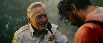 Movie still from “Savage Salvation” (2022), directed by Randall Emmett – An older man wearing a sheriff's badge talking to a young man; Close Up shot, Over the shoulder angle