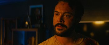 Movie still from “Savage Salvation” (2022), directed by Randall Emmett – A person with a beard looking at the camera; Close Up shot, Over the shoulder angle