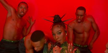 Movie still from “Savage x Fenty Show Vol. 3” (2021), directed by Alex Rudzinski – A woman in a green dress and a man in a red shirt; Close Up shot, Over the shoulder angle