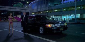 Movie still from “Savage x Fenty Show Vol. 3” (2021), directed by Alex Rudzinski – A man standing next to a black limo; Wide shot, Over the shoulder angle