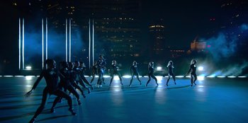 Movie still from “Savage x Fenty Show Vol. 3” (2021), directed by Alex Rudzinski – A group of people are dancing on a stage in the dark; Extreme Wide shot, High angle