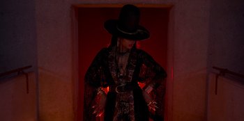 Movie still from “Savage x Fenty Show Vol. 3” (2021), directed by Alex Rudzinski – A woman wearing a black hat and a black dress; Medium shot, Low angle