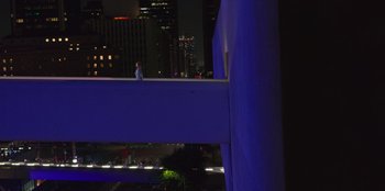 Movie still from “Savage x Fenty Show Vol. 3” (2021), directed by Alex Rudzinski – A person standing on top of a building at night; Extreme Wide shot, High angle