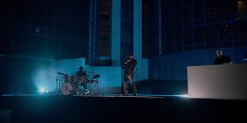 Movie still from “Savage x Fenty Show Vol. 3” (2021), directed by Alex Rudzinski – A man standing in front of a drum set on a stage; Extreme Wide shot, Low angle