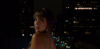 Movie still from “Savage x Fenty Show Vol. 3” (2021), directed by Alex Rudzinski – A beautiful woman standing in front of a city skyline at night; Close Up shot, Low angle
