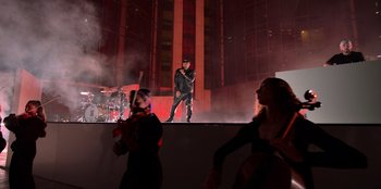 Movie still from “Savage x Fenty Show Vol. 3” (2021), directed by Alex Rudzinski – A man standing on top of a stage with a microphone; Extreme Wide shot, Low angle