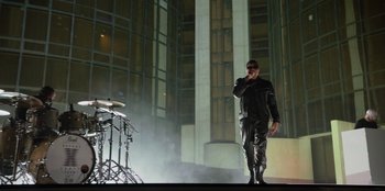 Movie still from “Savage x Fenty Show Vol. 3” (2021), directed by Alex Rudzinski – A man in a black leather jacket is on a cell phone; Wide shot, Low angle