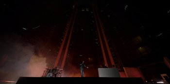 Movie still from “Savage x Fenty Show Vol. 3” (2021), directed by Alex Rudzinski – A man standing on top of a stage in front of an audience; Extreme Wide shot, High angle