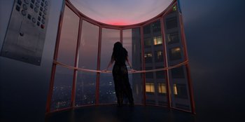 Movie still from “Savage x Fenty Show Vol. 3” (2021), directed by Alex Rudzinski – A woman standing in front of a window at night; Wide shot, Low angle