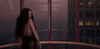 Movie still from “Savage x Fenty Show Vol. 3” (2021), directed by Alex Rudzinski – A woman standing in front of a window with a city view; Medium shot, Over the shoulder angle