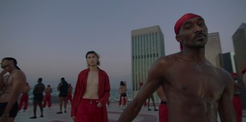 Movie still from “Savage x Fenty Show Vol. 3” (2021), directed by Alex Rudzinski – A group of people standing on top of a building near water; Medium shot, Low angle