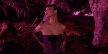 Movie still from “Savage x Fenty Show Vol. 4” (2022), directed by Alex Rudzinski – A woman in a black dress is standing in front of another woman; Medium shot, Low angle