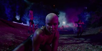 Movie still from “Savage x Fenty Show Vol. 4” (2022), directed by Alex Rudzinski – A woman with a shaved head poses for the camera; Medium shot, Low angle