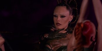 Movie still from “Savage x Fenty Show Vol. 4” (2022), directed by Alex Rudzinski – A woman in a black dress and some gloves; Close Up shot, Over the shoulder angle